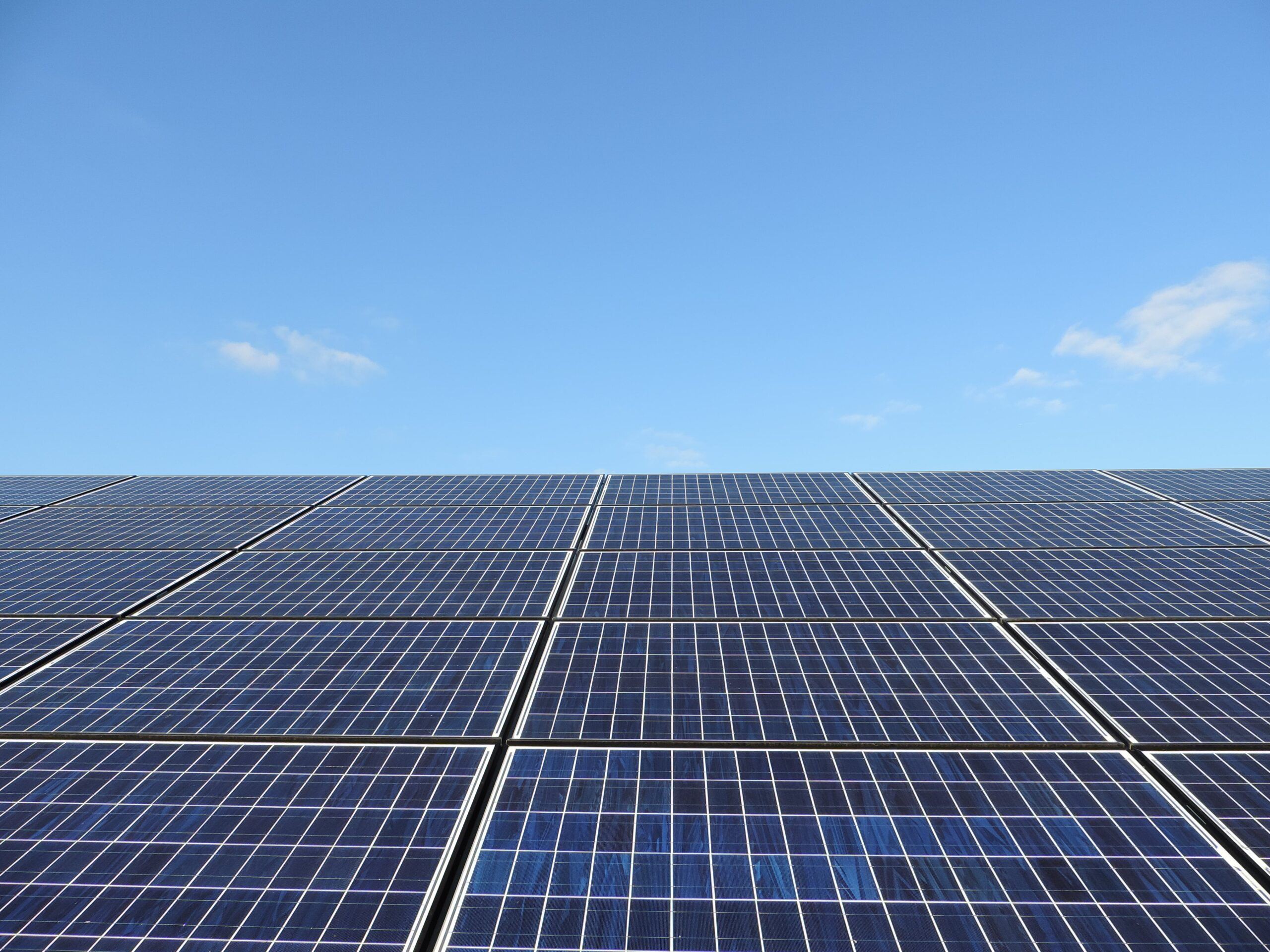 Solar panel array with blue sky above